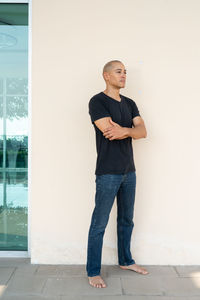 Young man standing against wall