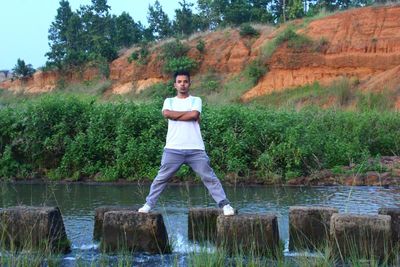 Portrait of young man standing by lake