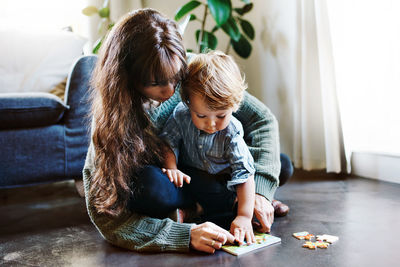 Rear view of mother and son sitting on table