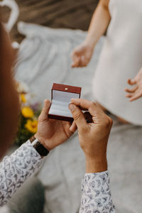 High angle view of man holding ring by woman