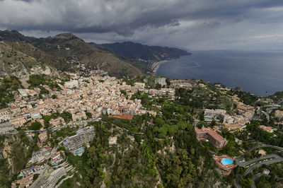 High angle view of townscape by sea against sky