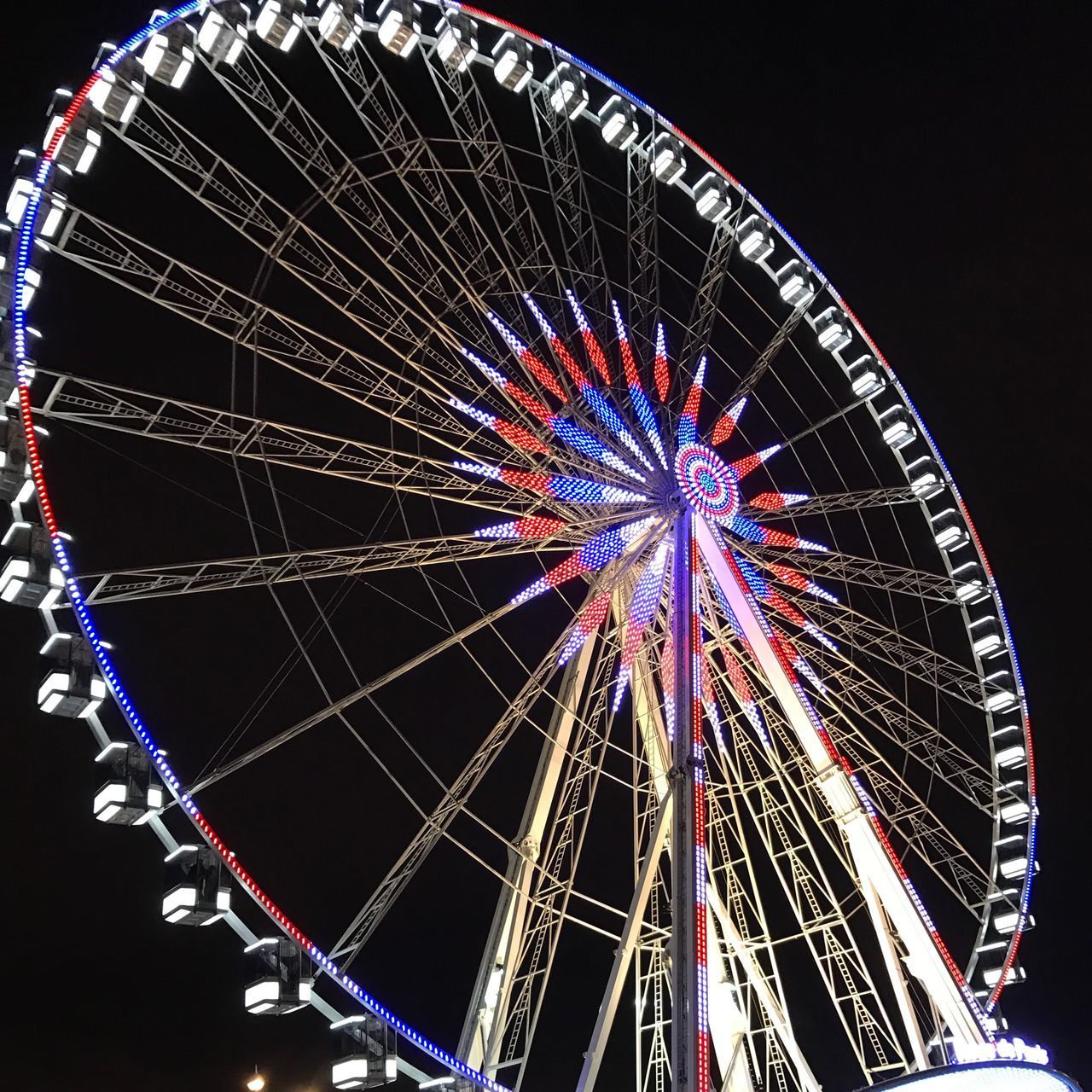 LOW ANGLE VIEW OF ILLUMINATED FERRIS WHEEL AT NIGHT