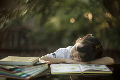 Close-up of girl sleeping while sitting at table