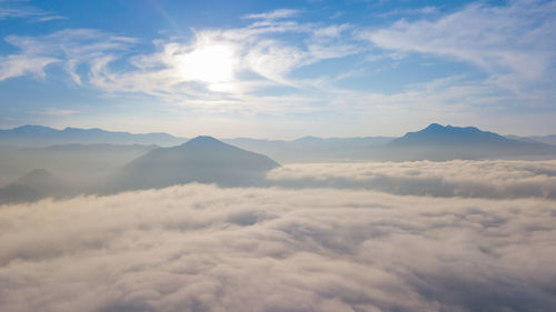 Scenic view of mountains against sky during sunrise with sea of clouds