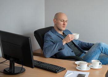 Businessman having coffee at desk in office