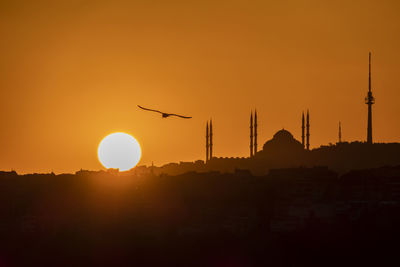 Silhouette buildings against sky during sunset