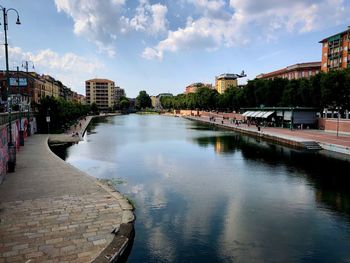 River amidst buildings in city against sky