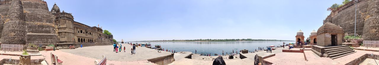 Panoramic view of people on beach against sky