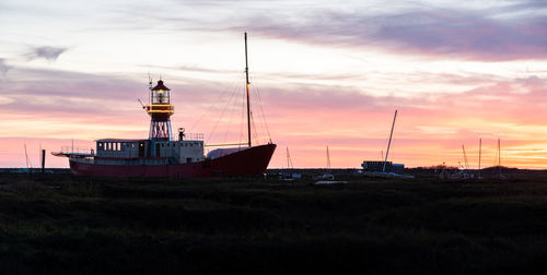 Silhouette sailboats moored on sea against sky during sunset