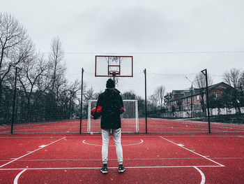 Rear view of man standing on field basketball 