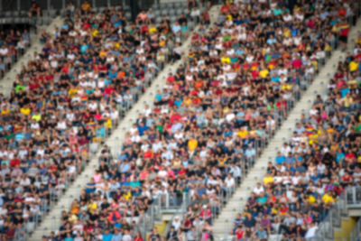 Defocused image of people sitting in stadium