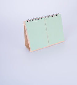 High angle view of blank green desk calendar on white background