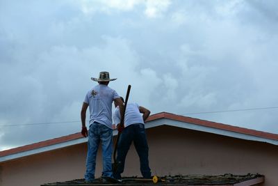 Rear view of man working against sky