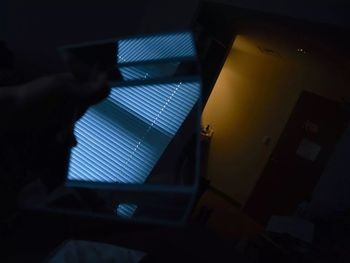 Low angle view of hand on window at night