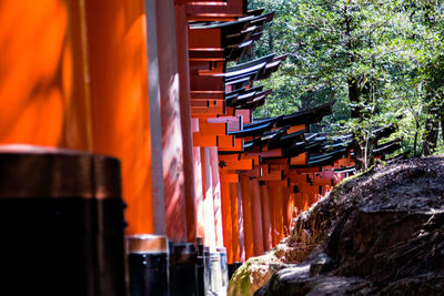 Row of building by trees against orange sky