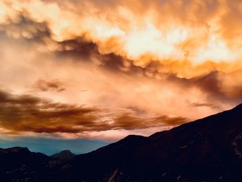 Scenic view of silhouette mountains against dramatic sky