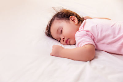 Cute girl sleeping on bed at home