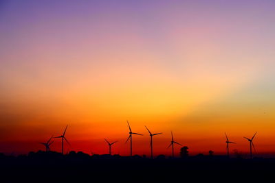 Silhouette of wind turbines at sunset