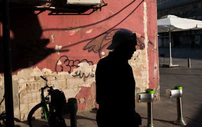 Rear view of woman standing against built structure