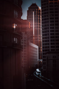 Illuminated buildings in city at sunset