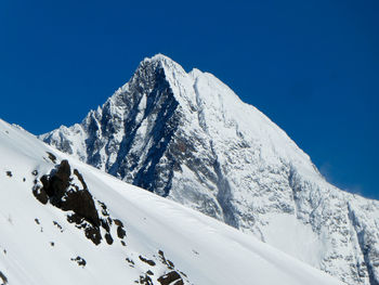 Scenic view of snowcapped mountains against clear blue sky