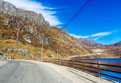 Road by mountain against sky