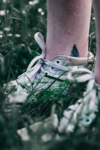 Low section of person wearing shoes on field