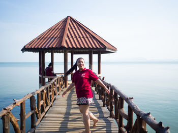 Full length portrait of man on pier over sea against sky