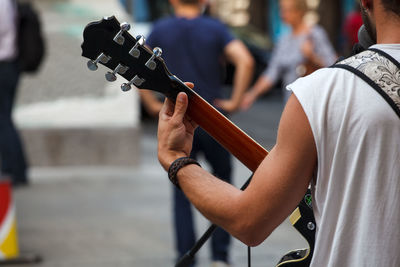 Midsection of man playing guitar