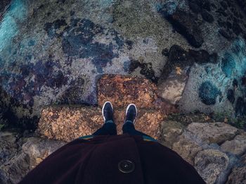 Low section of man standing on rock