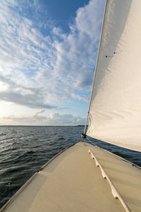 Sailboat sailing on sea against sky