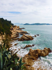 Scenic view of rocks in sea against sky