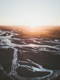 Scenic view of land against clear sky during sunset