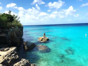 Women standing on rock in sea