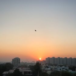 Silhouette cityscape against sky during sunset