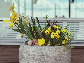 Close-up of yellow flower pot against wall