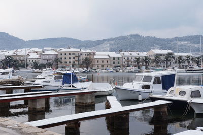 Boats moored at harbor against sky