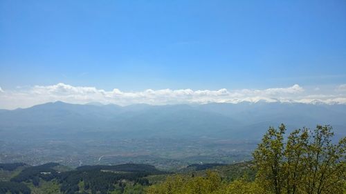 Scenic view of mountains against blue sky