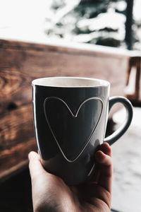 Close-up of hand holding coffee cup
