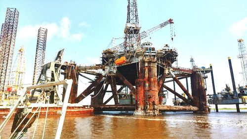 Low angle view of cranes against sky