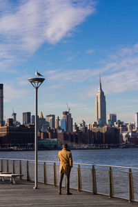 A rear view of a man looking at the new york city skyscrapers