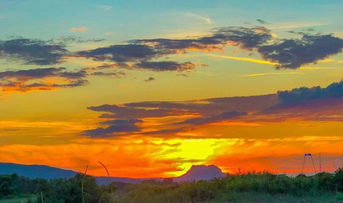 Scenic view of dramatic sky over landscape during sunset