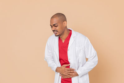 Young man looking away against white background