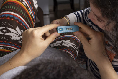 Midsection of woman holding pregnancy test kit at home