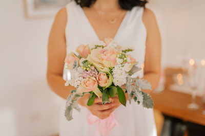 Holding pastel wedding bouquet pink roses