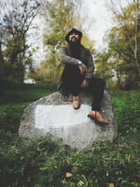 Mature man sitting on rock