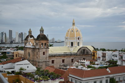 View of cathedral in city against cloudy sky