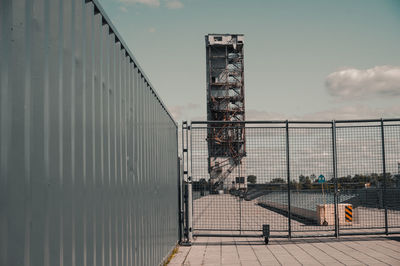 Metallic structure on street against sky