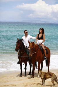 Couple riding horses at beach