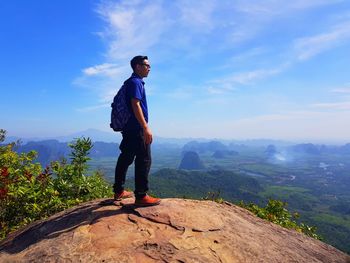 Full length of man standing on rock against sky